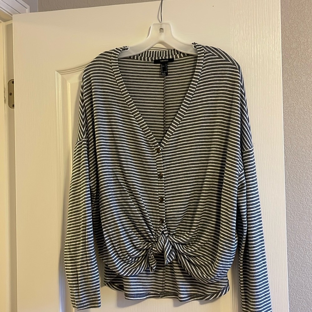 Striped gray and white button up sweater with tie on the bottom